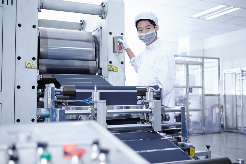 Worker in manufacturing facility at a conveyor belt